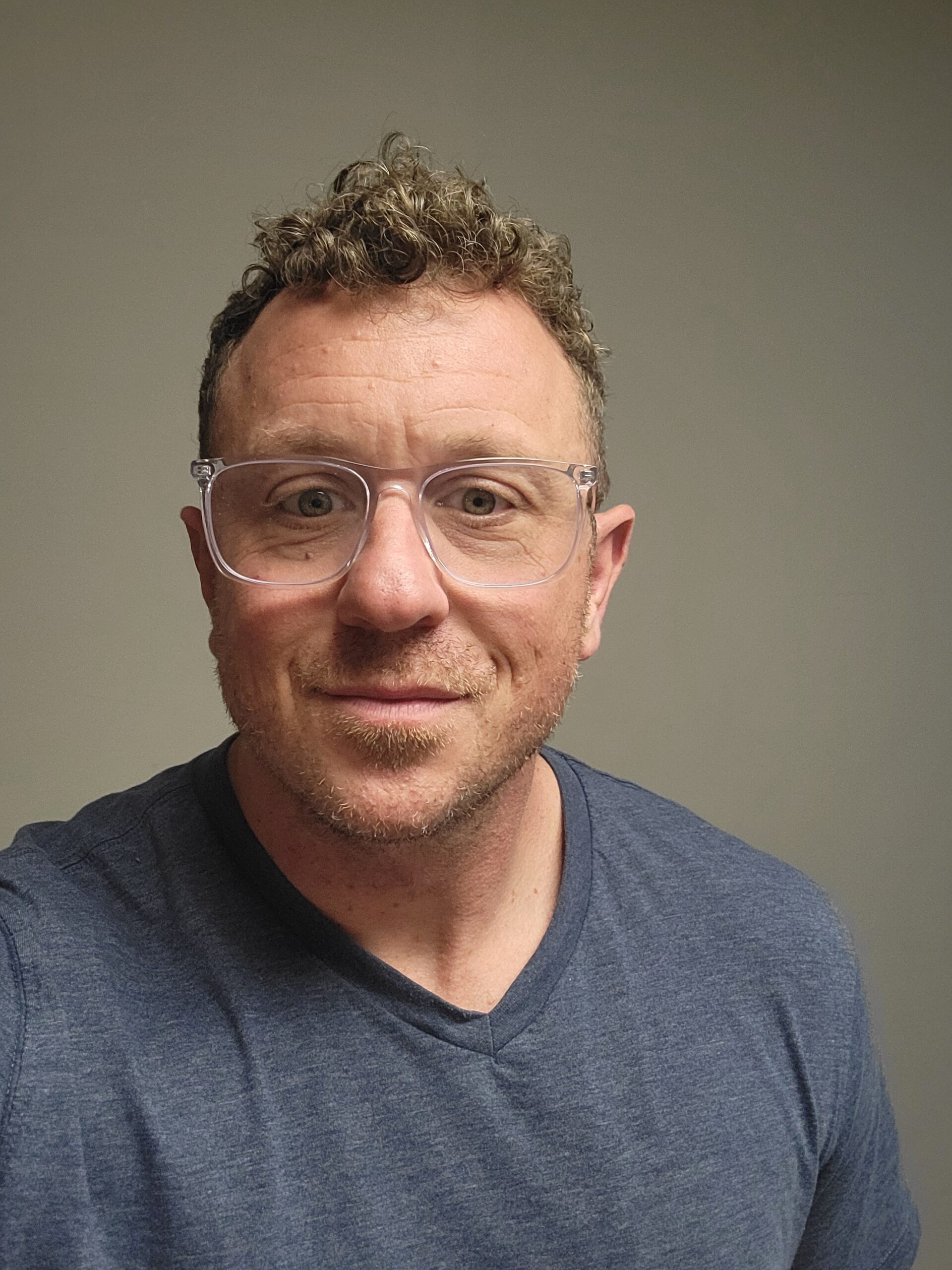 a man wearing glasses and looking at the camera